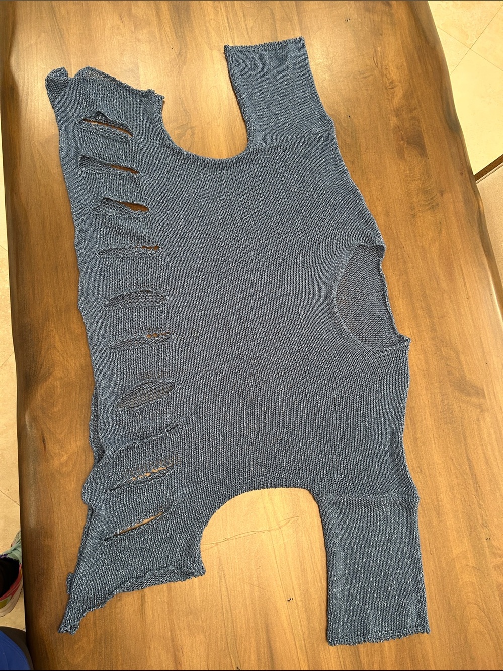 This garment is a distressed cut-out knit top